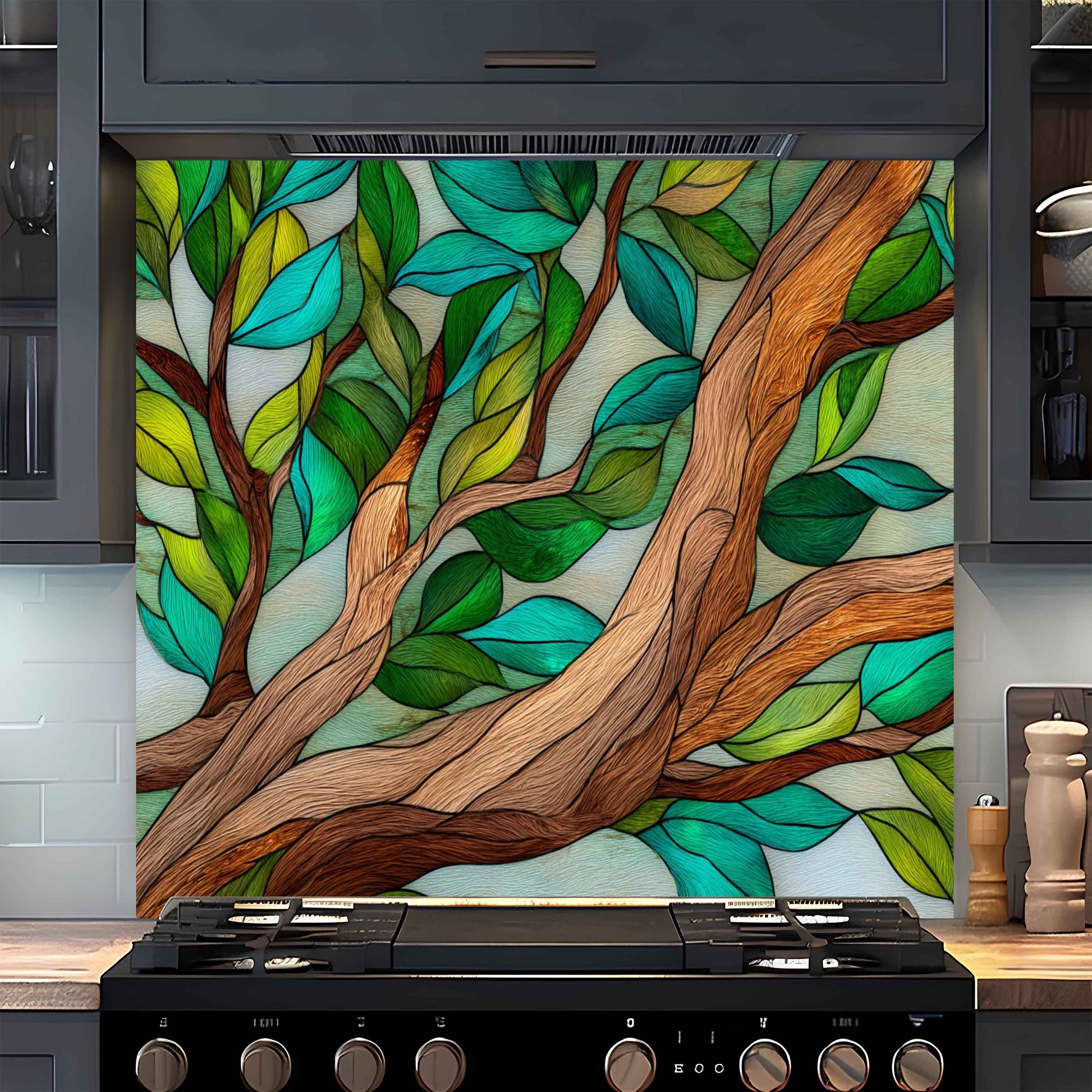 Decorative glass panel with tree design above a stove in a kitchen.