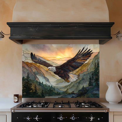 Decorative glass splashback with an eagle design above a stove in a kitchen.