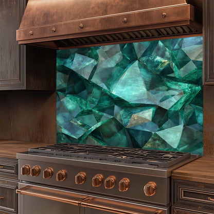 Stainless steel stove with copper accents and a geometric green glass backsplash in a kitchen setting.